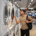 Man choosing washing machine in shop