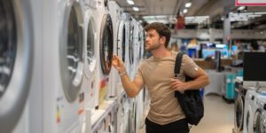 Man choosing washing machine in shop