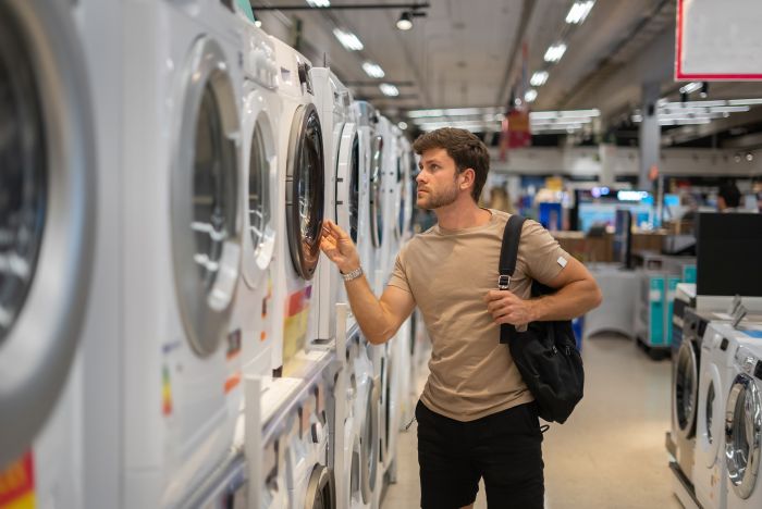 Man choosing washing machine in shop