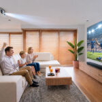 Familia viendo fútbol en el salón con un proyector láser 4K de Epson.