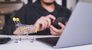 Persona usando el smartphone y el portátil para comprar online.